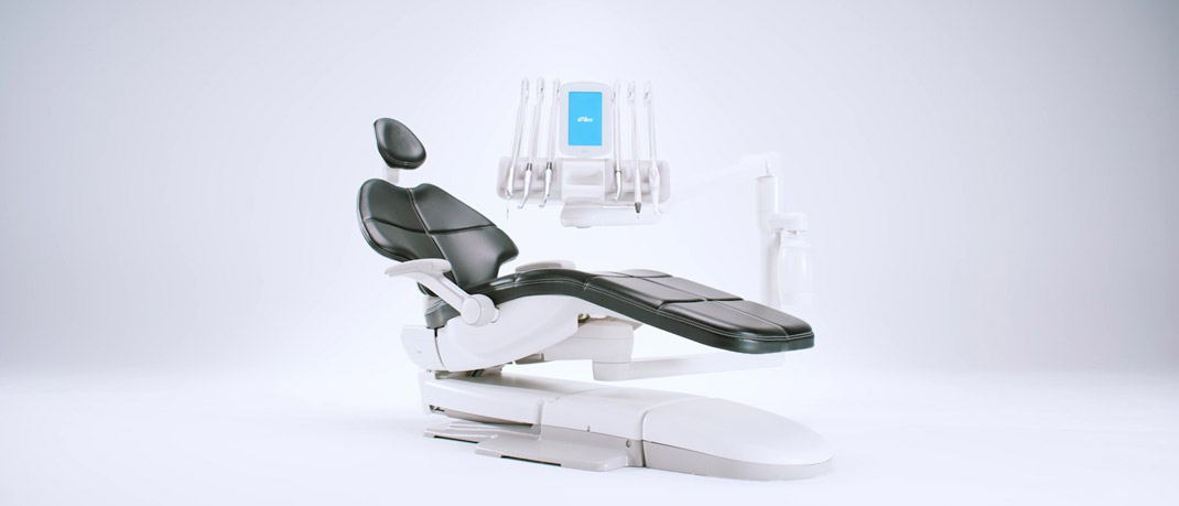 An A-dec dental chair with black upholstery and a chair-mounted delivery system on a gray gradient background