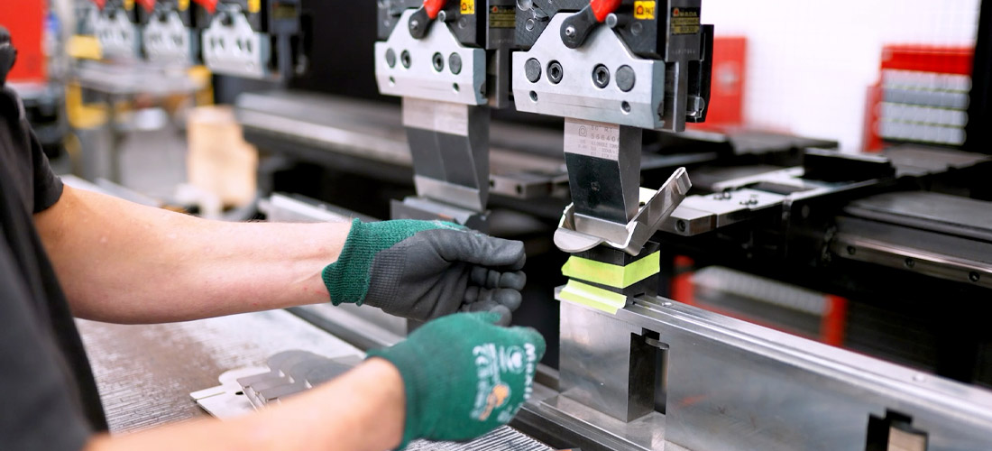 A-dec worker using a metal stamping machine to make dental equipment parts