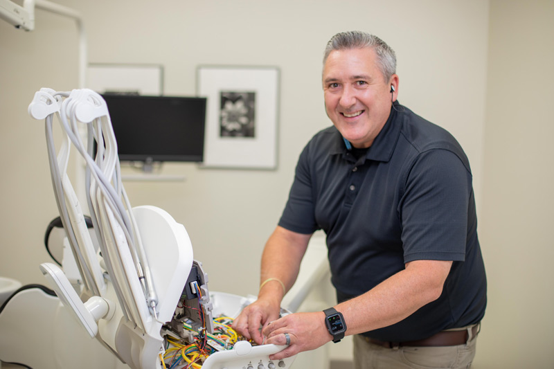 A-dec service technician installing A-dec parts into a dental delivery system