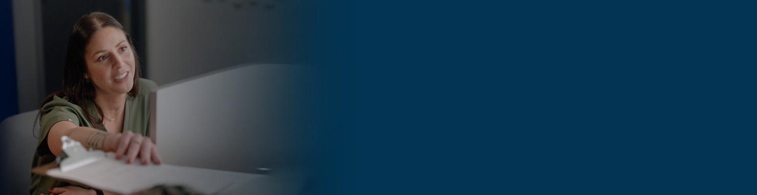 Image of office assistant passing papers to a patient