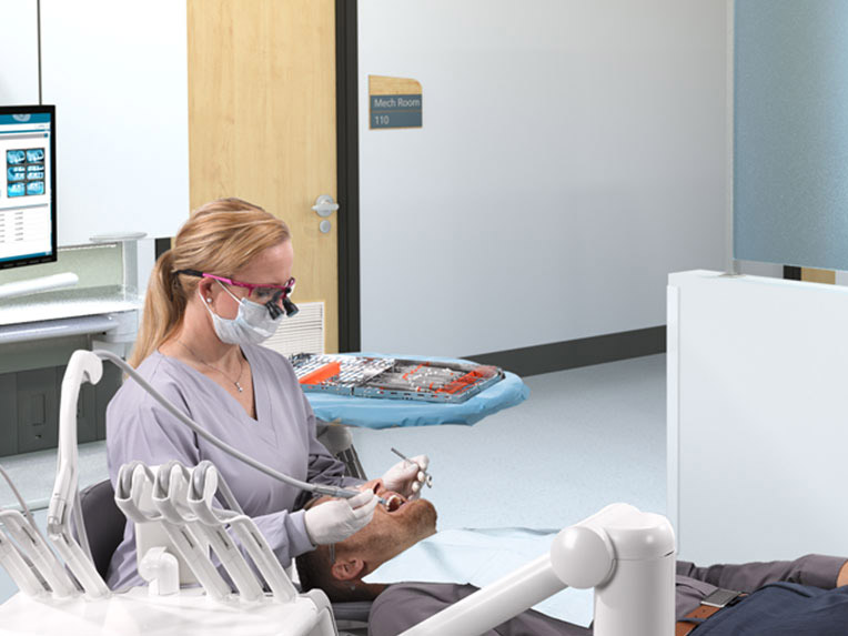 Dental hygienist working on patient in front of a closed-door mechanical room